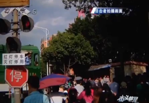 中年男子为拍照强闯道口