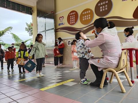 萌贝尔幼儿园小朋友自觉站在“一米线”后等候晨检.jpg